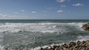 Las ondas del mar se rompen contra una piedra en la orilla Las ondas del mar se rompen contra una piedra en la orilla