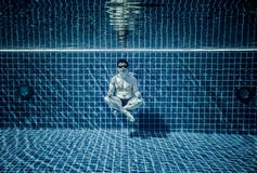 Las personas mienten debajo del agua en una piscina Fotos de archivo Las personas mienten debajo del agua en una piscina Fotos de archivo