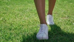 Las piernas femeninas delgadas en los zapatos blancos van derecho almacen de video Las piernas femeninas delgadas en los zapatos blancos van derecho almacen de video