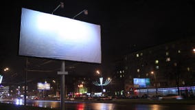 Lasso di tempo della scena urbana con un tabellone per le affissioni vuoto, di notte Lasso di tempo della scena urbana con un tabellone per le affissioni vuoto, di notte