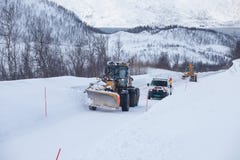 Lastbilen för snöplogen som gör klar den iskalla vägen efter vintersnöstormhäftiga snöstormen för blåsare för medeltill arkivfoto Lastbilen för snöplogen som gör klar den iskalla vägen efter vintersnöstormhäftiga snöstormen för blåsare för medeltill arkivfoto