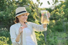 Lato plenerowy portret kobieta z naturalnym napojem robić od truskawki mennicy ziele, kobiety ogrodnictwo fotografia stock Lato plenerowy portret kobieta z naturalnym napojem robić od truskawki mennicy ziele, kobiety ogrodnictwo fotografia stock