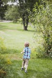 Laufende Außenseite des glücklichen Jungen Lizenzfreie Stockbilder Laufende Außenseite des glücklichen Jungen Lizenzfreie Stockbilder