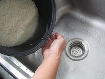 Lavage de riz sur l'évier dans la cuisine photo stock Lavage de riz sur l'évier dans la cuisine photo stock