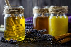 Lavender και το βοτανικό μέλι στα βάζα γυαλιού με το μέλι μετακινούν με το κουτάλι στο σκοτεινό ξύλινο υπόβαθρο στοκ εικόνες Lavender και το βοτανικό μέλι στα βάζα γυαλιού με το μέλι μετακινούν με το κουτάλι στο σκοτεινό ξύλινο υπόβαθρο στοκ εικόνες