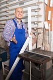 Lavoratore soddisfatto alla fabbrica delle finestre del PVC immagini stock libere da diritti Lavoratore soddisfatto alla fabbrica delle finestre del PVC immagini stock libere da diritti