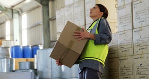 Lavoratrice che soffre dal dolore alla schiena mentre tenendo scatola pesante 4k Lavoratrice che soffre dal dolore alla schiena mentre tenendo scatola pesante 4k