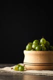 Le bacche mature succose di un'uva spina in un piccolo vaso di legno sul nero sorgono Raccolto dell'uva spina Fotografia Stock Le bacche mature succose di un'uva spina in un piccolo vaso di legno sul nero sorgono Raccolto dell'uva spina Fotografia Stock