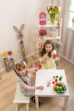 Le bambine sono fatte di Pasqua - dipingono, essi assorbono la stanza fotografia stock Le bambine sono fatte di Pasqua - dipingono, essi assorbono la stanza fotografia stock