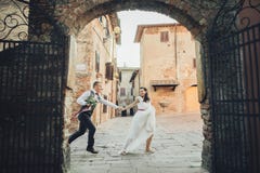 Le beau couple étreignant de mariage se tient avant les portes à un vieux images libres de droits Le beau couple étreignant de mariage se tient avant les portes à un vieux images libres de droits