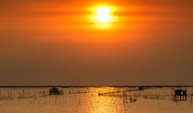 Le beau soleil en été Ciel de coucher du soleil au-dessus de la mer, de la hutte du pêcheur et de la forêt de palétuvier le soir images libres de droits Le beau soleil en été Ciel de coucher du soleil au-dessus de la mer, de la hutte du pêcheur et de la forêt de palétuvier le soir images libres de droits