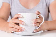 Le belle mani della giovane donna con le unghie naturali manicure la tenuta della tazza di caffè fotografia stock libera da diritti Le belle mani della giovane donna con le unghie naturali manicure la tenuta della tazza di caffè fotografia stock libera da diritti