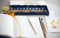 Le bureau de l'artiste sur quels carnet à dessins, brosses, aquarelle et peintures de gouache photo stock Le bureau de l'artiste sur quels carnet à dessins, brosses, aquarelle et peintures de gouache photo stock