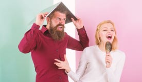 Le chant est sa passion Madame chantent employant la brosse de cheveux comme microphone tandis que l'homme ennuyait la dissimulat images libres de droits Le chant est sa passion Madame chantent employant la brosse de cheveux comme microphone tandis que l'homme ennuyait la dissimulat images libres de droits