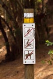 Le chemin de terre de l'Europe à la forêt de pin avec la limitation de signe entrent en la bicyclette, à cheval, moto À pied seul images stock Le chemin de terre de l'Europe à la forêt de pin avec la limitation de signe entrent en la bicyclette, à cheval, moto À pied seul images stock