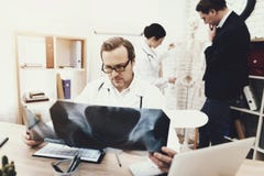 Le chirurgien expérimenté avec le stéthoscope diagnostique le patient regardant le rayon X image libre de droits Le chirurgien expérimenté avec le stéthoscope diagnostique le patient regardant le rayon X image libre de droits