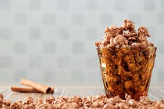 Le chocolat a assaisonné le maïs éclaté dans le verre jaune et sur la table en bois brune avec le fond de cannelle images stock Le chocolat a assaisonné le maïs éclaté dans le verre jaune et sur la table en bois brune avec le fond de cannelle images stock