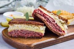 Le classique reuben le sandwich, servi avec le pickle à l'aneth, des pommes chips, horizontales image libre de droits Le classique reuben le sandwich, servi avec le pickle à l'aneth, des pommes chips, horizontales image libre de droits