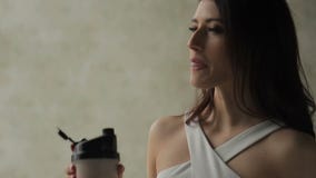 Le cocktail attrayant de protéine de boissons de femme est en appartement Le cocktail attrayant de protéine de boissons de femme est en appartement
