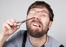 Le coiffeur masculin coupe ses propres cheveux dans le nez, regardant l'appareil-photo comme le miroir coiffeur professionnel élé photos stock Le coiffeur masculin coupe ses propres cheveux dans le nez, regardant l'appareil-photo comme le miroir coiffeur professionnel élé photos stock