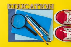 Le concept de l'éducation Espadrilles rouges, fournitures scolaires, livres, carnets avec le fond jaune image libre de droits Le concept de l'éducation Espadrilles rouges, fournitures scolaires, livres, carnets avec le fond jaune image libre de droits