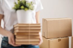 Le concept de la relocalisation et du déplacement à une nouvelle maison Les mains en gros plan et femelles tiennent une pile des images stock Le concept de la relocalisation et du déplacement à une nouvelle maison Les mains en gros plan et femelles tiennent une pile des images stock
