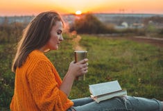 Le concept de la récréation extérieure de mode de vie en automne La fille a lu des livres sur le plaid avec une tasse thermo Auto images libres de droits Le concept de la récréation extérieure de mode de vie en automne La fille a lu des livres sur le plaid avec une tasse thermo Auto images libres de droits