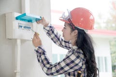 Le contrôle femelle asiatique d'électricien ou d'ingénieur ou inspectent le disjoncteur de système électrique image libre de droits Le contrôle femelle asiatique d'électricien ou d'ingénieur ou inspectent le disjoncteur de système électrique image libre de droits