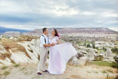 Le coppie di amore di San Valentino negli abbracci e baci della natura, uomo e donna si amano Montagne del cappadocia in tacchino immagini stock libere da diritti Le coppie di amore di San Valentino negli abbracci e baci della natura, uomo e donna si amano Montagne del cappadocia in tacchino immagini stock libere da diritti