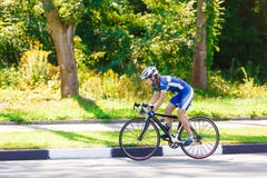Le cycliste féminin monte un vélo de emballage sur la route Images libres de droits Le cycliste féminin monte un vélo de emballage sur la route Images libres de droits