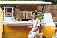 Le den asiatiska mannen som anv?nder mobiltelefonen arkivbild Le den asiatiska mannen som anv?nder mobiltelefonen arkivbild