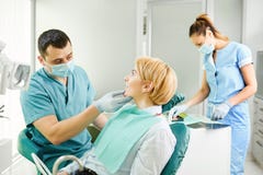 Le dentiste examine les dents de la fille patiente photographie stock Le dentiste examine les dents de la fille patiente photographie stock