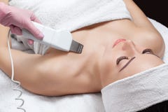 Le docteur-cosmetologist fait à l'appareil une procédure du nettoyage d'ultrason de la peau decollete d'un beau, jeune femme photos stock Le docteur-cosmetologist fait à l'appareil une procédure du nettoyage d'ultrason de la peau decollete d'un beau, jeune femme photos stock