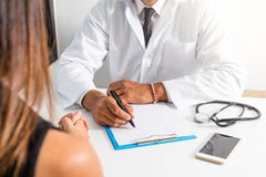 Le docteur et le patient discutent au sujet du diagnostic Médecin tenant un stéthoscope et prenant des notes images libres de droits Le docteur et le patient discutent au sujet du diagnostic Médecin tenant un stéthoscope et prenant des notes images libres de droits
