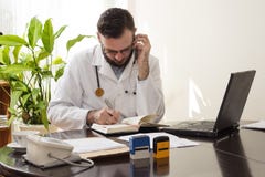 Le docteur pendant un appel téléphonique enregistre le rendez-vous dans le calendrier images stock Le docteur pendant un appel téléphonique enregistre le rendez-vous dans le calendrier images stock