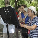 Le donne cinesi anziane godono di di cantare in un parco a Pechino Fotografia Stock Libera da Diritti Le donne cinesi anziane godono di di cantare in un parco a Pechino Fotografia Stock Libera da Diritti