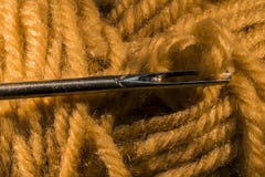 Le détail du fil jaune de laine a fileté sur une aiguille image stock Le détail du fil jaune de laine a fileté sur une aiguille image stock