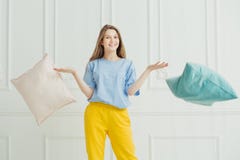 Le flickan som kastar kuddar Lycklig skämtsam kvinna i pyjama royaltyfria foton Le flickan som kastar kuddar Lycklig skämtsam kvinna i pyjama royaltyfria foton