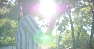 Le flickasammanträde parkera in att se till sidan och drinkvattnet från en glasflaska lager videofilmer Le flickasammanträde parkera in att se till sidan och drinkvattnet från en glasflaska lager videofilmer