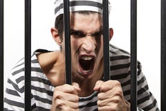 Le forçat hurle par des barres de prison photographie stock Le forçat hurle par des barres de prison photographie stock