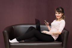 Le free lance fanno il lavoro mentre si siedono a casa sullo strato fotografia stock Le free lance fanno il lavoro mentre si siedono a casa sullo strato fotografia stock