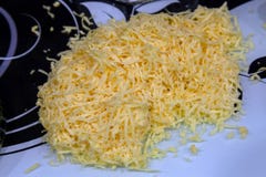 Le fromage jaune râpé sur une planche à découper pour faire cuire est noir et photographie stock libre de droits Le fromage jaune râpé sur une planche à découper pour faire cuire est noir et photographie stock libre de droits