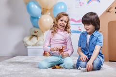 Le garçon et la fille heureux de sourire ont l'amusement chez la pièce des enfants Images libres de droits Le garçon et la fille heureux de sourire ont l'amusement chez la pièce des enfants Images libres de droits