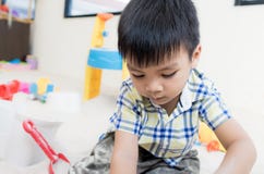 Le garçon joue avec des jouets de bac à sable dans le terrain de jeu éducatif photographie stock Le garçon joue avec des jouets de bac à sable dans le terrain de jeu éducatif photographie stock