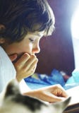 Le garçon a lu le livre dans le lit avec le chat Le garçon a lu le livre dans le lit avec le chat