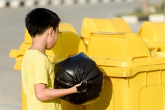 Le garçon portent des déchets dans le sac pour éliminent à la poubelle images libres de droits Le garçon portent des déchets dans le sac pour éliminent à la poubelle images libres de droits