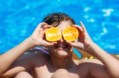 Le garçon sportif mignon nage dans la piscine avec l'anneau de beignet et a l'amusement, sourires, oranges de prises vacances ave photographie stock Le garçon sportif mignon nage dans la piscine avec l'anneau de beignet et a l'amusement, sourires, oranges de prises vacances ave photographie stock