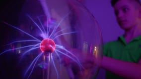 Le garçon étonné allume la lampe sans électricité Le garçon étonné allume la lampe sans électricité