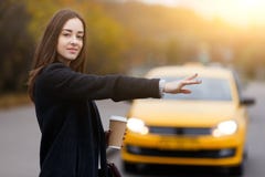 Le geste de main de femme de brune attrape le taxi Looking modèle à l'appareil-photo photographie stock Le geste de main de femme de brune attrape le taxi Looking modèle à l'appareil-photo photographie stock