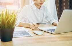 Le giovani donne stanno comperando online sul computer portatile nella mia casa Da pagamento con carta di credito Il concetto mod Immagini Stock Libere da Diritti Le giovani donne stanno comperando online sul computer portatile nella mia casa Da pagamento con carta di credito Il concetto mod Immagini Stock Libere da Diritti